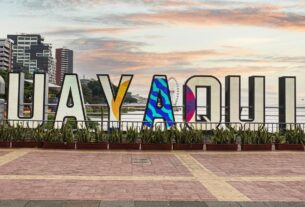 Letreiro com as letras que formam a palavra Guayaquil posicionadas junto ao rio Guayas