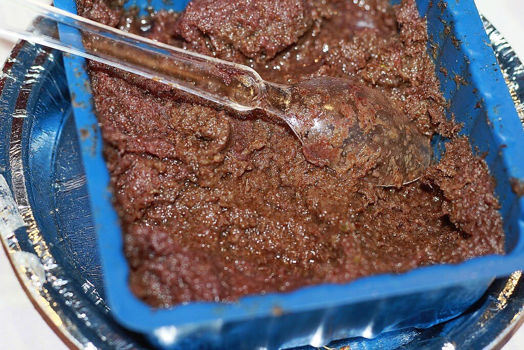 Recipiente azul contendo um chutney, molho ensopado da culinária indiana, sobre um laminado. A culinária indiana é considerada uma das culinarias mais exóticas do mundo.